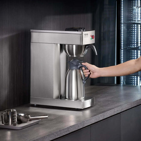 Person using 12 Cup Commercial Drip Coffee Maker With Thermal Vacuum Carafe Keeps Coffee Hot Or Cold All Day No Fuss For Restaurant Office Cafe Stainless Steel Brewer That Brews A Full Pot In About 9 Minutes on countertop.