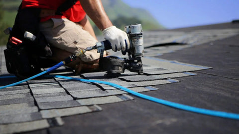 Worker using a nail gun connected to Heavy Duty Three Eighths Inch By One Hundred Foot Blue Polyurethane Air Hose With Braided Nylon Reinforcement