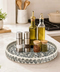 Game Changing 12.5 Inch Wooden Lazy Susan Turntable With A Smooth Swivel Base Sharp Black Leaf Design And Authentic Mother Of Pearl Inlay showcasing spices and oils.