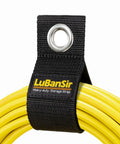 Close-up of 9 Pack Heavy Duty Extension Cord Holder Organizers For Garage Wall Storage with yellow cord in a black strap with grommet.