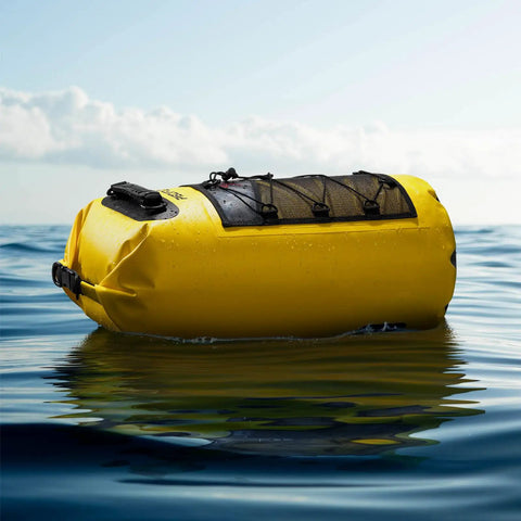 Yellow floating dry bag suitable for water sports, showcasing durable design and waterproof material in ocean setting.