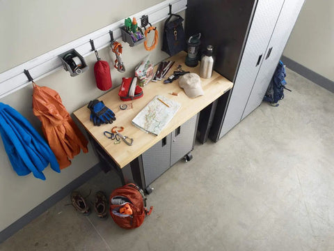 Garage setup with Heavy Duty Welded Steel Hooks For Garage Wall Storage, 8 Pack, holding coats and tools, above a workbench.