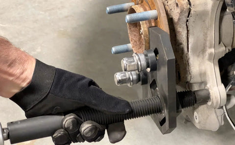 Lisle 40100 hub remover installed on brake hub with black mounting plate and threaded studs