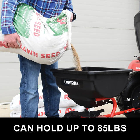 Man pouring lawn seed into 85 Lb Tow Behind Broadcast Spreader With Direct Rod Control Wide 4 To 8 Ft Spread Heavy Duty Frame
