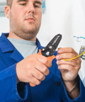 Man using Tough As Nails Wire Stripper Pliers With Cushioned Safety Lock And Stainless Steel Blades on electrical wire.