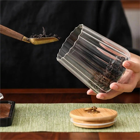 Level Up Your Kitchen With This Tough Clear Glass Storage Jar Boasting A Tight Airtight Wooden Lid Sealed Cap For Grains Coffee Beans Candy And Spices To Keep Everything Fresh On Hand with dried tea leaves.