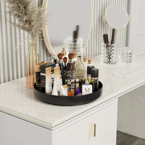 Front view of Ovicar 13-inch black metal Lazy Susan turntable on vanity, filled with makeup bottles, tubes, and brushes.