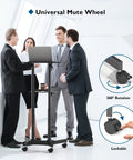Business meeting using On Wheels Portable Standing Laptop Desk With Height Adjustable Sit Stand 0 To 40 Degree Tilt Rolling Cart.