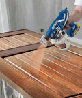 Top Notch Cordless Handheld Airless Paint Sprayer For Quick Touch Ups And Lacquer Projects spraying brown lacquer on a wooden door.