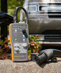 Slick Heavy Duty Type One Electric Vehicle Charging Station Diagnostic Adapter For Testing Level 1 And Level 2 Ac Systems With Gfci And Ground Safety Checks Plug Right In resting on a stone surface.