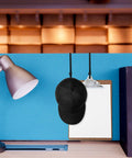 Four Pack Cubicle Coat Hooks For 2 Inch Wide Panels, Double Arm Metal Hangers holding a black cap and clipboard on cubicle wall