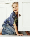 Child playing and smiling near a white cabinet with Vintage Rose Flower Cabinet Knobs Two Pack Classic Floral Drawer Pulls.