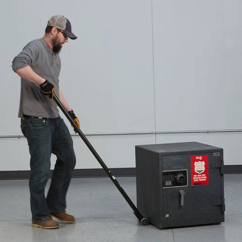 Person using Heavy Duty Pry Bar Lever With 6600 Lb Capacity, 55 Inch Handle, Special Nose Plate And Four Steel Rollers for lifting a safe.