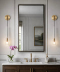 XYDikssn Crystal Wall Sconces, Brushed Gold Brass Wall Lights with Clear Crystal Glass beside mirror in elegant bathroom setting.
