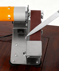 Pro Grade Mini Belt Sander And 15 Degree Electric Spindle Knife Sharpener featuring a knife being sharpened on its belt.