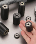 Close-up of 4 Pack Plastic Roller Wheels With Bearings For Conveyor Systems And Warehouse Carts, Guiding Belt Idler Rollers, held in hand