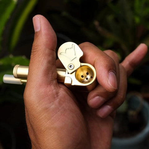 Hand holding Brass Portable All In One Tool With Poker And Storage Tube CNC Machined Precision Multitool for DIYers Made in Hawaii.