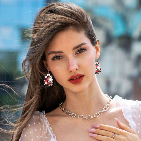 Dope Poker Suit Dangle Drop Earrings Featuring Bold Grid Card Pattern worn by a woman with a chain necklace and stylish blouse.