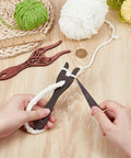 Hands using Three Piece Wooden Knitting Fork And Weaving Tools Kit With Lucet Fork For Bracelet And Necklace Braiding DIY Projects In Boxwood And Beech Wood Durable And Lightweight For Comfortable Use And Long Lasting DIY Craft Sessions on wooden surface with yarn.