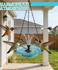 Hanging Bird Bath Fountain With Glass Bowl, USB Powered Cascading Water Feature attracting hummingbirds in a garden.