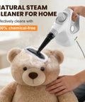 Powerful Portable Handheld Steamer Shooting Scalding Vapor To Wreck Stubborn Pan Grease And Baked On Filth On Tile Linoleum And Fabric Seats With 14 Heavy Duty Tools For No Sweat Scrubbing And Spotless Shine, cleaning a teddy bear head.