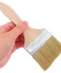 Hand holding Do It All Three Piece Wood Handle Paint Brush Set With Natural Bristle For Walls, Furniture, Decks And Stain Jobs