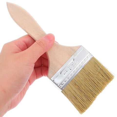 Hand holding Do It All Three Piece Wood Handle Paint Brush Set With Natural Bristle For Walls, Furniture, Decks And Stain Jobs