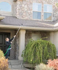 Person using 2-Pack Telescoping Watering Tool With Five-Position Pole Extending From 3.5 To 6 Feet, Four Spray Patterns to clean roof