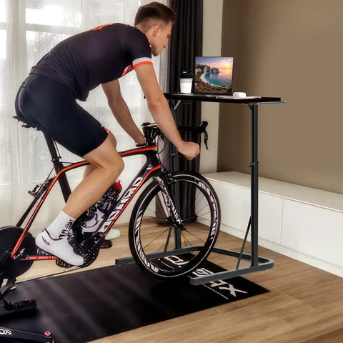 Person cycling indoors using Adjustable Treadmill Desk With Walking Pad Stand For Home Office And Bike Trainer A Versatile Standing Workstation