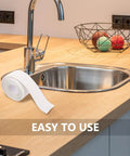 Super Easy White PVC Caulking Tape For Bathtub And Window Gaps Peels Sticks And Seals To Stop Water Leaks Without Messy Tools on kitchen counter next to sink.