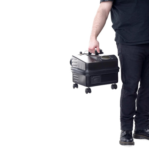 Person holding a portable heavy duty commercial steam cleaner with 90 psi and 325 degrees dual boiler setup for continuous refill.