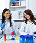 Two women in a lab wearing unisex white lab coats for adults with long sleeves, stain resistant polyester, all day comfort for doctors and science pros.