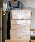 5 Inch X 492 Ft Stretch Roll Handle, Self Adhesive Shrink Film for Packing Moving Storage being used to secure boxes during packing.