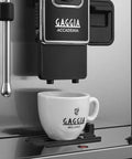 Top Tier Heavy Hitter Italian Fully Automatic Espresso Machine With Brushed Stainless Steel Housing pouring into a Gaggia cup.
