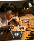 Child using Magnetic Third Hand Soldering Aid With Built In Magnifier For Crafts And PCB Work at a workbench
