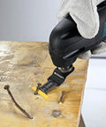 Front view of a black-blue oscillating multitool with a titanium blade cutting nails from a wooden board.