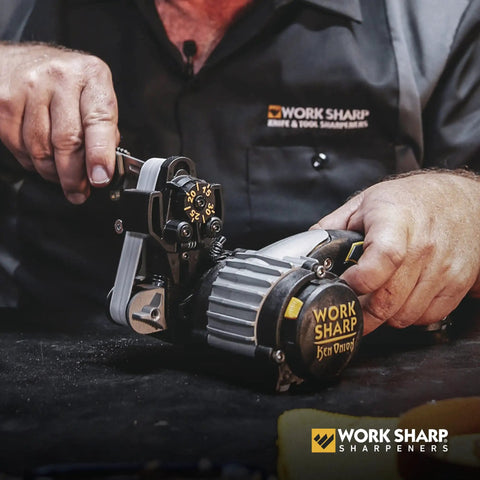 Person using Work Sharp Ken Onion Edition sharpener with assorted belt kit for knife sharpening.