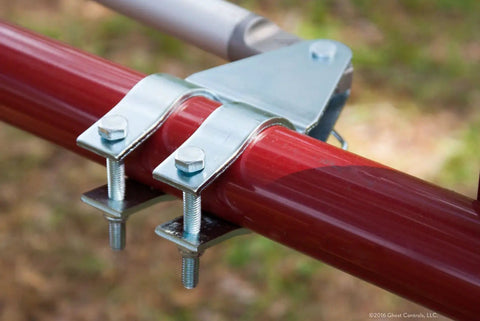 Close-up of heavy duty solar dual automatic gate opener kit featuring metal bracket and bolts on red swing gate