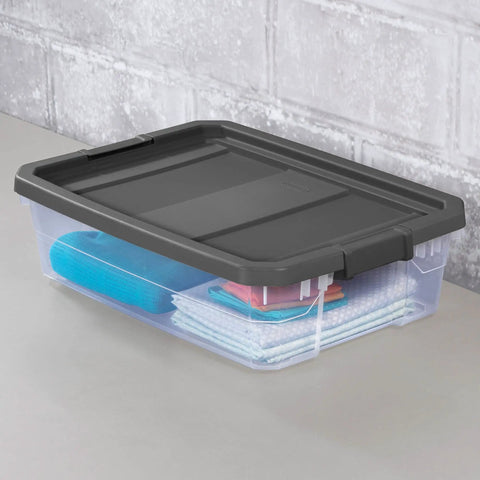 Box Stacker Modular Clear 40 Quart Storage Bin For Easy Organization And Space Saving Stackable See Through Plastic Container With Durable Build And Latching Lid No Fuss Garage Pantry And Closet 14743V06 with black lid, storing items inside, on a gray surface.