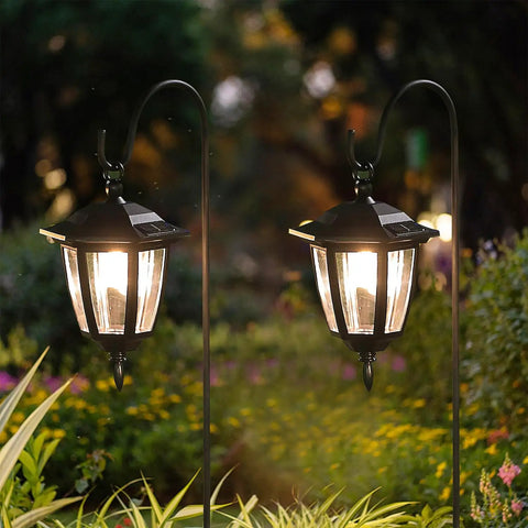 Solar Hanging Lights For Outdoors, 2 Pack With 38 Inch Shepherd Hooks, illuminating garden path at twilight, warm white LED glow.