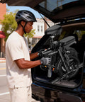 Man loading Foldable 14 Inch Electric Bike For Adults With 1500W Peak Motor Top Speed 20 MPH Removable 48V 16Ah Battery into car trunk