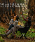 Two people sitting outdoors enjoying nature on a Go To Ultra Lightweight Camping Chair For Outdoors Easy Fold Portable Lawn Chair
