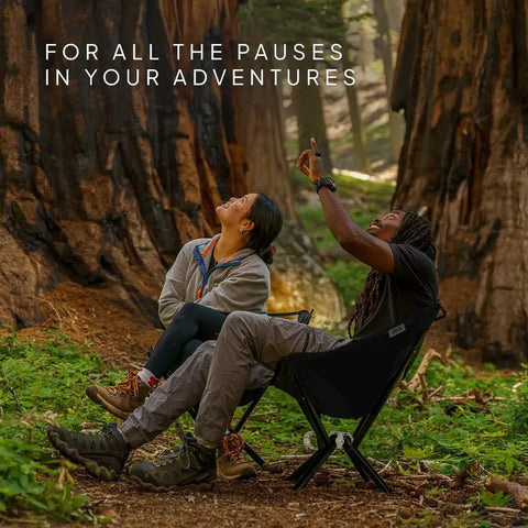 Two people sitting outdoors enjoying nature on a Go To Ultra Lightweight Camping Chair For Outdoors Easy Fold Portable Lawn Chair