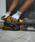 Badass Cordless Brushless Belt Sander With Six Variable Speed Settings and Raw Grip in use, sanding rough wood close-up.