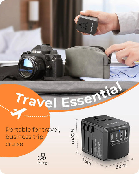 Universal Travel Power Adapter With 2 USB C Ports And 2 USB A Ports Worldwide Wall Charger shown next to camera and travel bag.