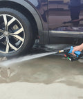 Using Beefed Up 5000 PSI Pressure Washer Gun With 360 Degree Swivel And Five Quick Connect Nozzles for cleaning car tire and driveway.