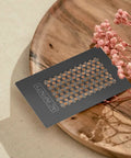 Grinder Card Manual Pepper And Spice Grater Tool In Black Aluminum on wooden tray with flowers