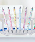 Colorful custom pens displayed in clear holder, perfect for Professional Grade Sublimation Pens Bulk Pack Ready For Heat Press Including Shrink Wrap Films Bright White Coating For Custom Markers And Dope Craft Creations Daily.