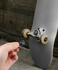 Hand holding pivot cup near longboard truck, 8 Pack Longboard Truck Pivot Cups Replacement For Most Longboards 18mm And 16mm With Deck Guards Protector And Hardware Set For A Smooth Ride And Built To Last.