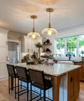 Slick Oil Rubbed Bronze One Light Pendant Ceiling Lamp With Retro Dome Glass Shade over kitchen island with plants and decor.